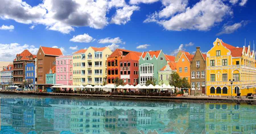 Pastel Dutch-gabled waterfront buildings reflected in calm water at Willemstad, Curacao