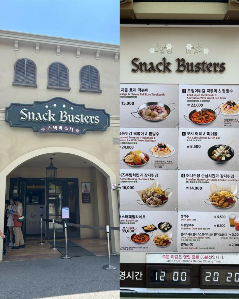 Snack Busters storefront at Everland beside its menu board of tteokbokki and fried chicken