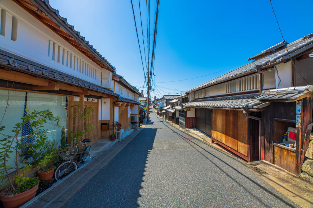 A narrow street lined with traditional wooden machiya houses in Naramachi, Nara