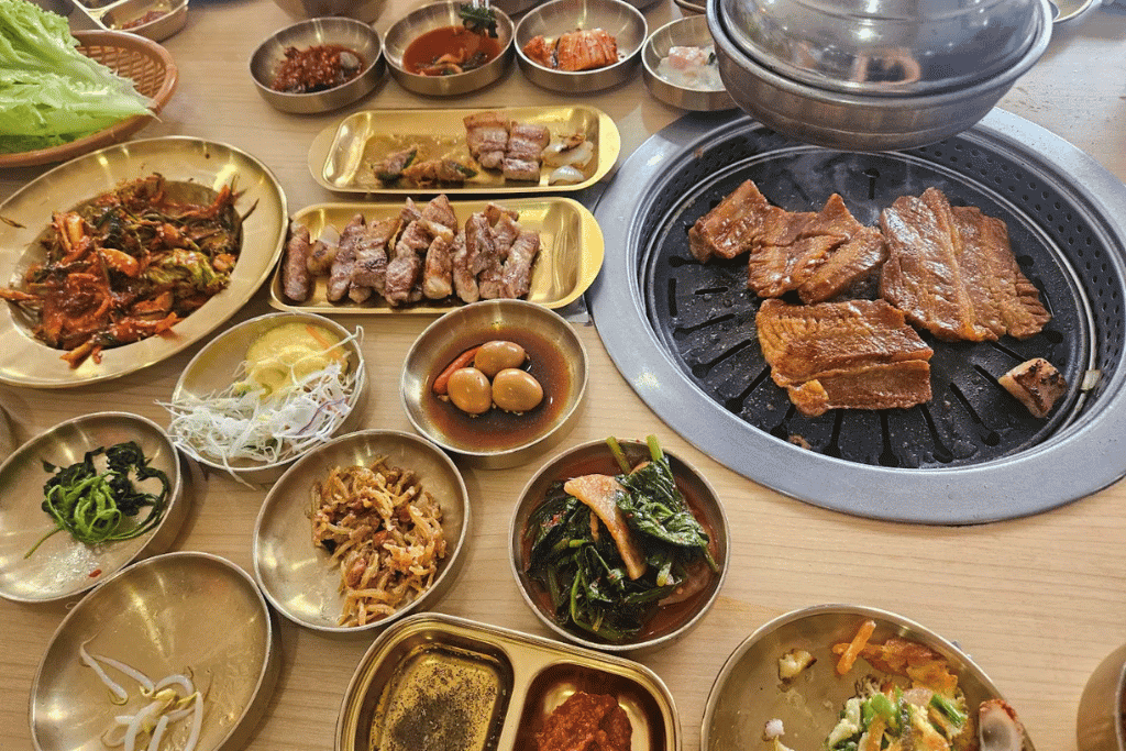 Grilled pork belly, banchan and a seafood side dish at Jeju Korea BBQ Restaurant