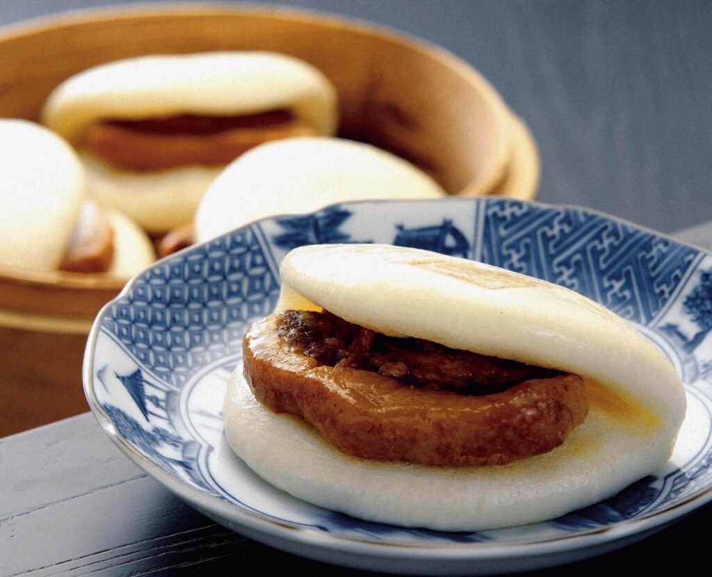A steamed kakuni manju bun stuffed with slow-braised pork belly