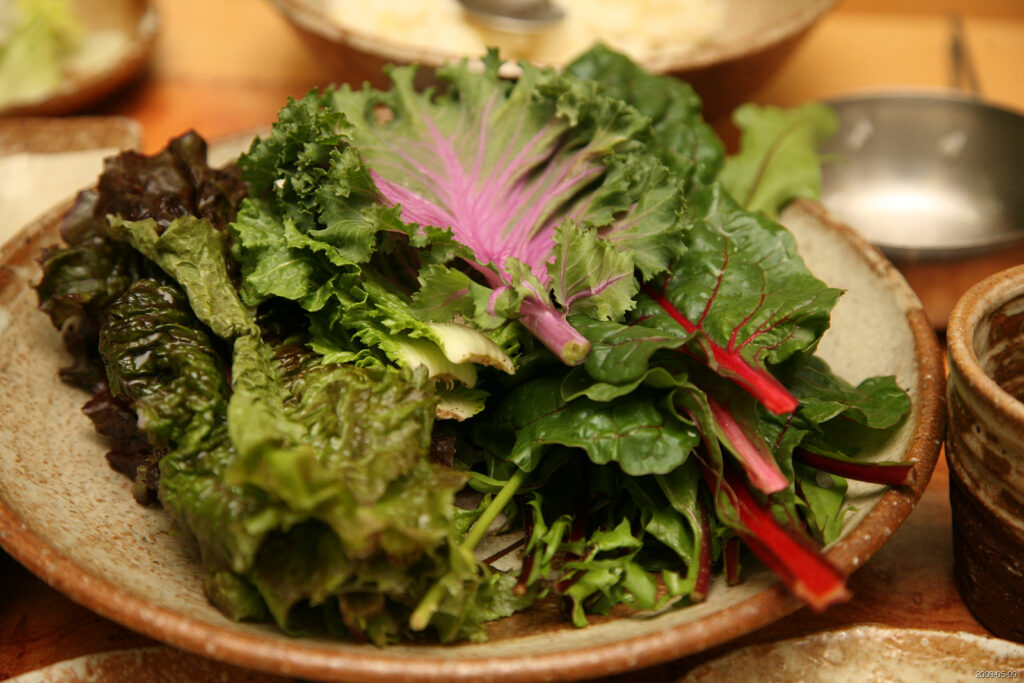 Bowl of lettuce, chard and purple kale leaves for wrapping, part of a ssambap spread