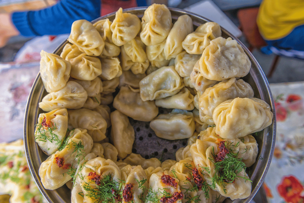 Steamed manty dumplings filled with minced meat and onion, served with sour cream