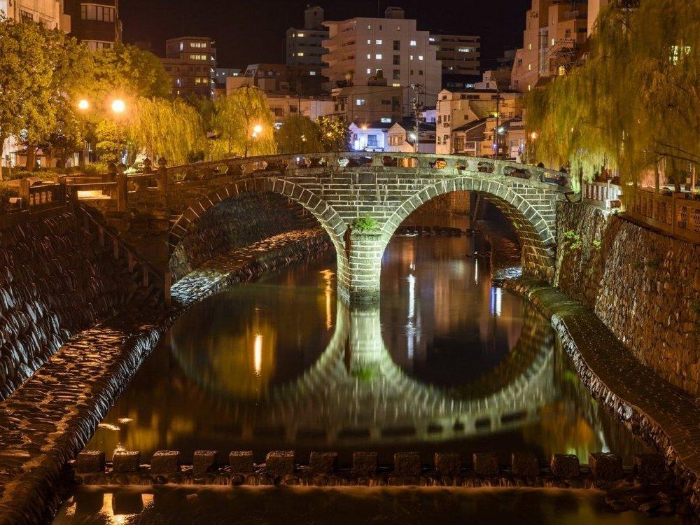Meganebashi's twin stone arches reflecting on the Nakashima River at night