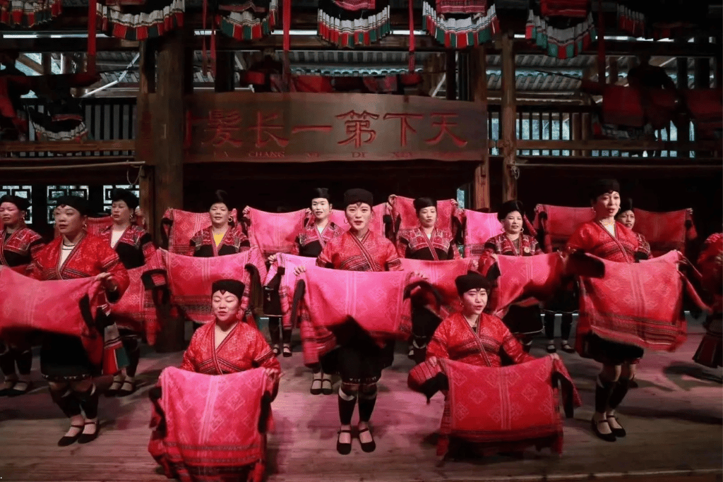 Red Yao women in red costume performing on stage at Huangluo Yao Village