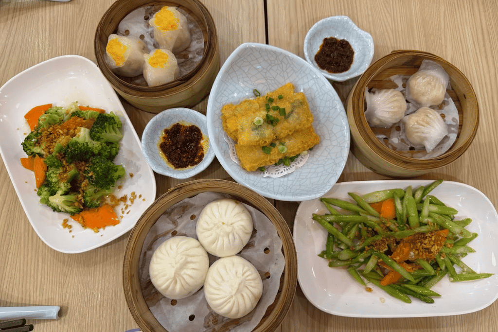 A spread of steamed dim sum, char siu bao and stir-fried vegetables at The Dim Sum Place