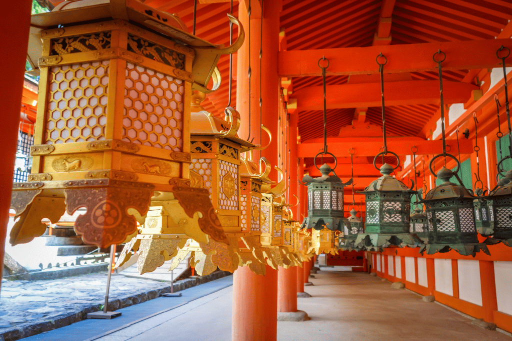 Rows of hanging bronze and gold lanterns along a covered walkway at Kasuga Taisha shrine
