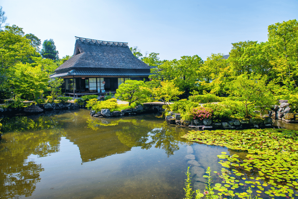 Yoshikien Garden's pond garden with a traditional Japanese house and lily pads