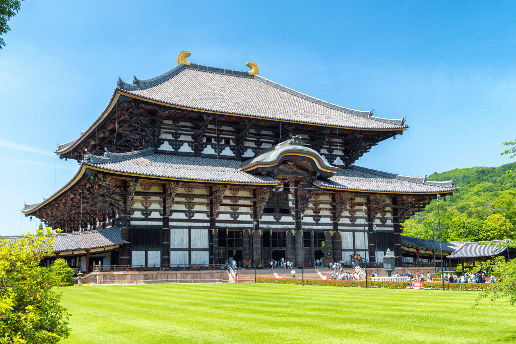Todai-ji Temple's wooden Great Buddha Hall with its curved roof and green lawn