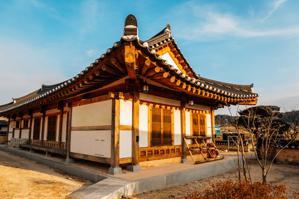 Restored hanok with a tiled roof and timber pillars under a clear winter sky
