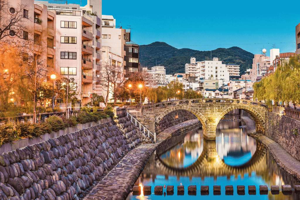 Meganebashi stone bridge and reflection glowing at dusk in central Nagasaki