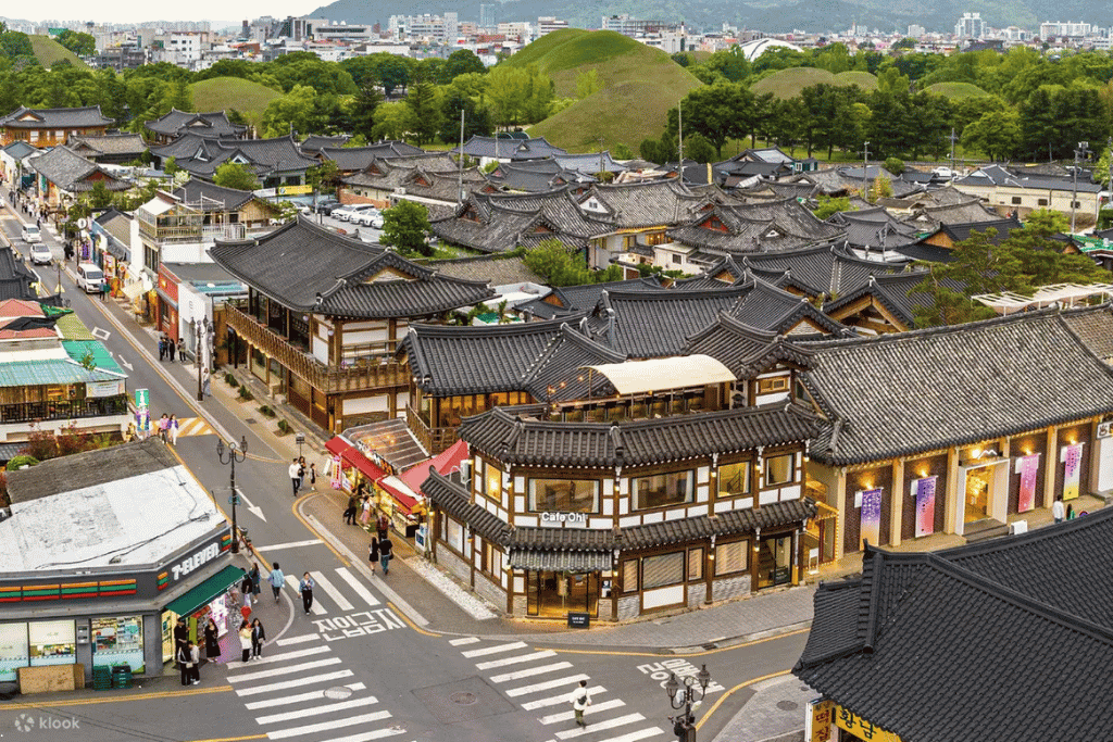 Hanok cafés and shops along Hwangnidan-gil, with the burial mounds rising behind the rooftops