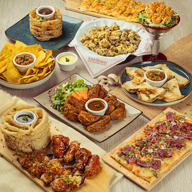 Onion rings, wings and quesadillas on a table at Tony Roma's