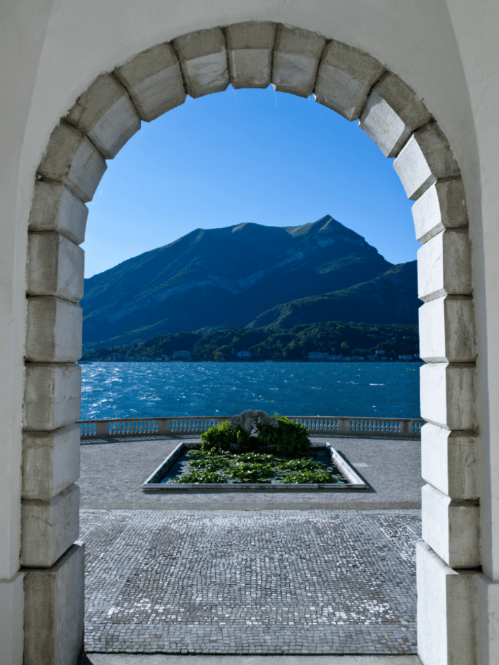 Stone archway framing a mountain and lake view