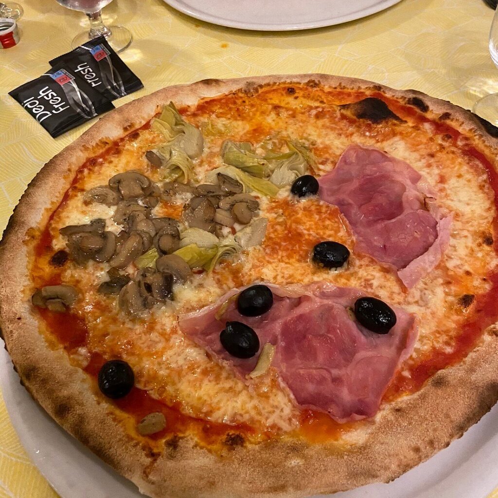 Wood-fired pizza with ham, mushrooms and olives at Cavallo Bianco