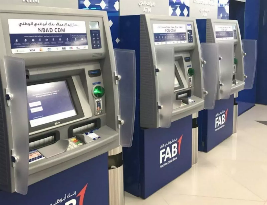 Row of bank ATMs inside a UAE bank branch, including a First Abu Dhabi Bank machine