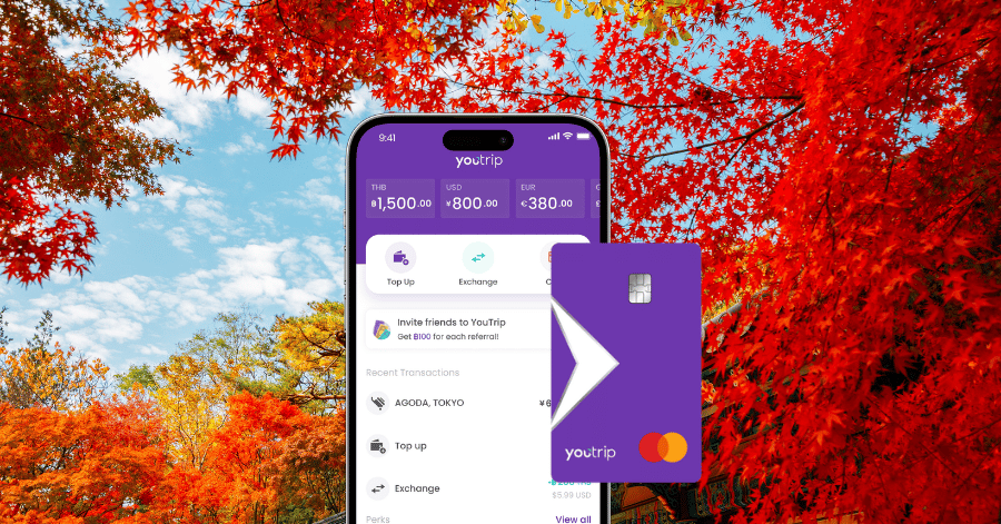 YouTrip app screen showing multi-currency balances and a YouTrip card over red autumn maple leaves