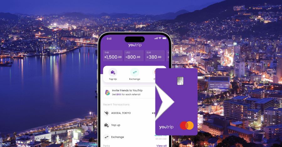 The YouTrip app and multi-currency card over a night view of Nagasaki