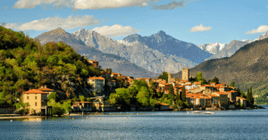 Terracotta-roofed lakeside village with snow-capped Alps behind