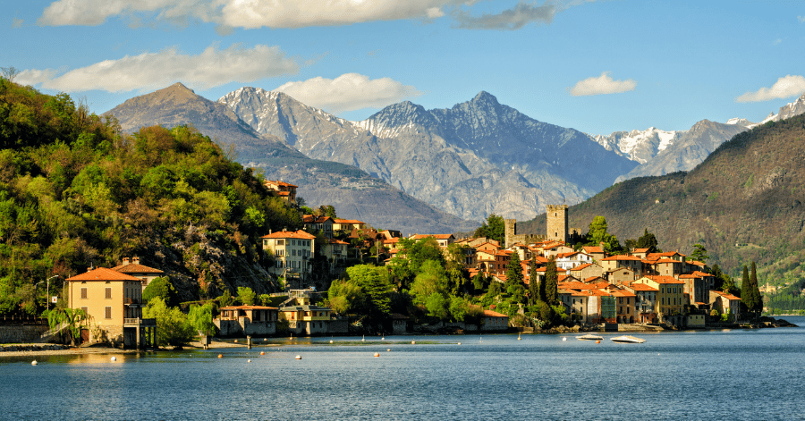 Terracotta-roofed lakeside village with snow-capped Alps behind