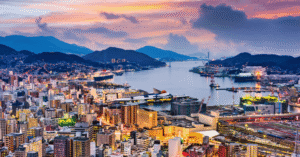 Aerial view of Nagasaki city and harbour glowing at sunset from Mount Inasa