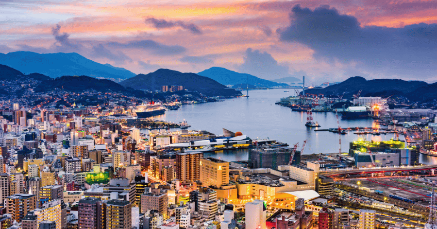 Aerial view of Nagasaki city and harbour glowing at sunset from Mount Inasa