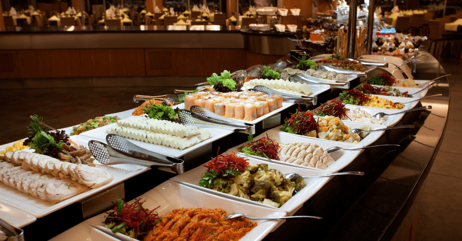 A long hotel buffet counter with rows of salads, cold cuts, and seafood dishes