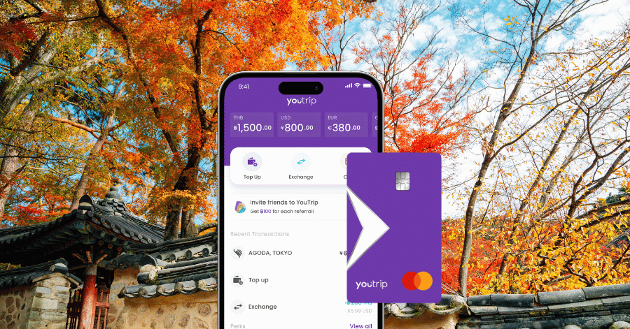 YouTrip app showing multiple currency wallets beside the purple card, against autumn trees at a hanok