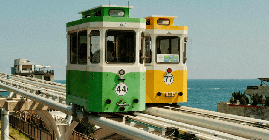 Green and yellow sky capsule cars on the elevated seaside rail at Busan's Blueline Park