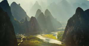 Rows of limestone karst peaks along the Li River lit gold at sunrise