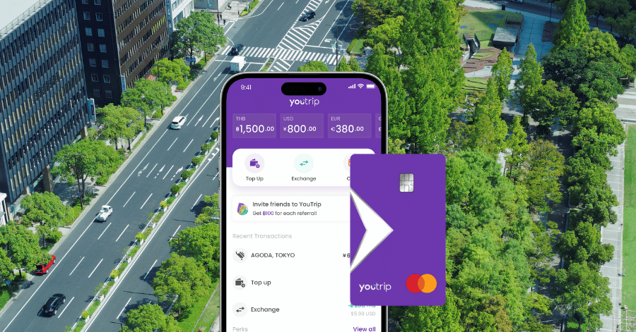 The YouTrip app multi-currency wallet screen and card shown over a city street