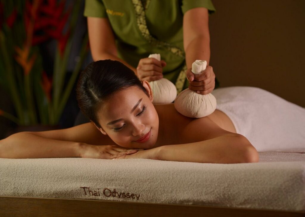 Therapist giving a herbal compress massage at Thai Odyssey in Komtar JBCC