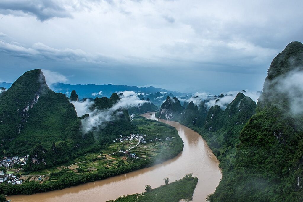 Aerial view of the Li River curving through misty karst peaks near Xianggong Mountain