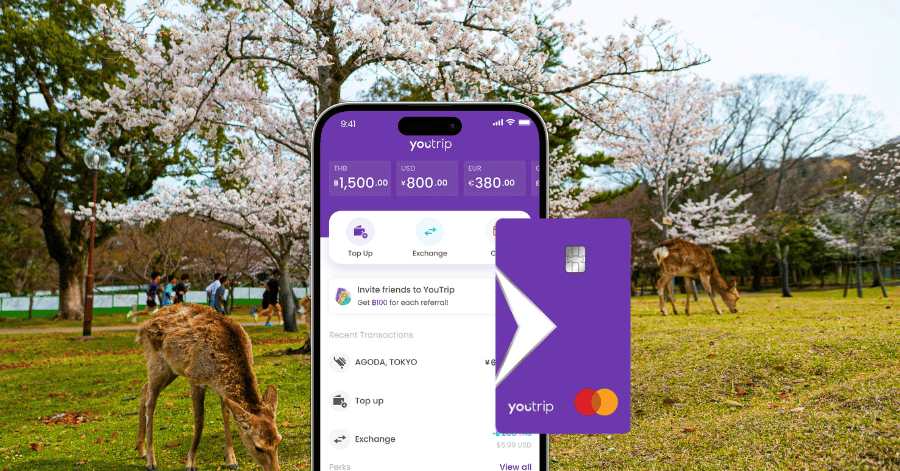 The YouTrip multi-currency app and card shown over a photo of deer under cherry blossoms in Nara