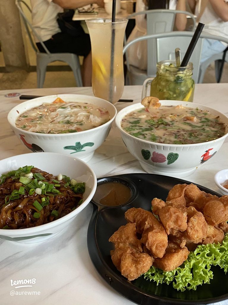 Two bowls of fish head noodle soup and a plate of fried seafood at Hai Kah Lang JB Sentosa