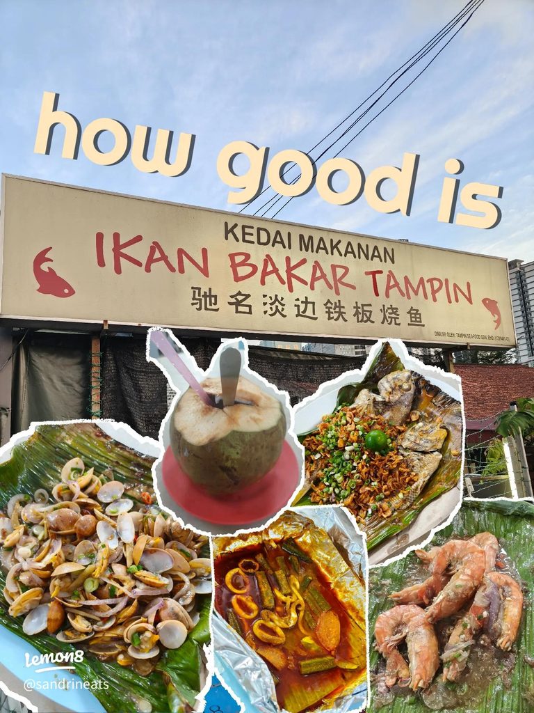 Ikan Bakar Tampin's storefront signage above grilled whole fish, clams, and prawns wrapped in banana leaf