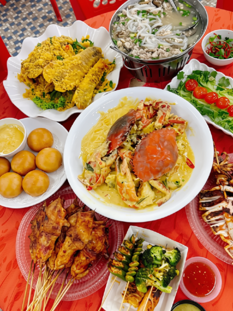 A BBQ and seafood spread with crab, satay skewers, and fried buns at Kedai Makanan Sin Kimdo