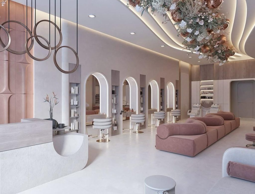 Salon interior with pink arched styling stations and a lounge seating area
