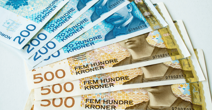 Fanned Norwegian 200 and 500 krone banknotes on a white surface