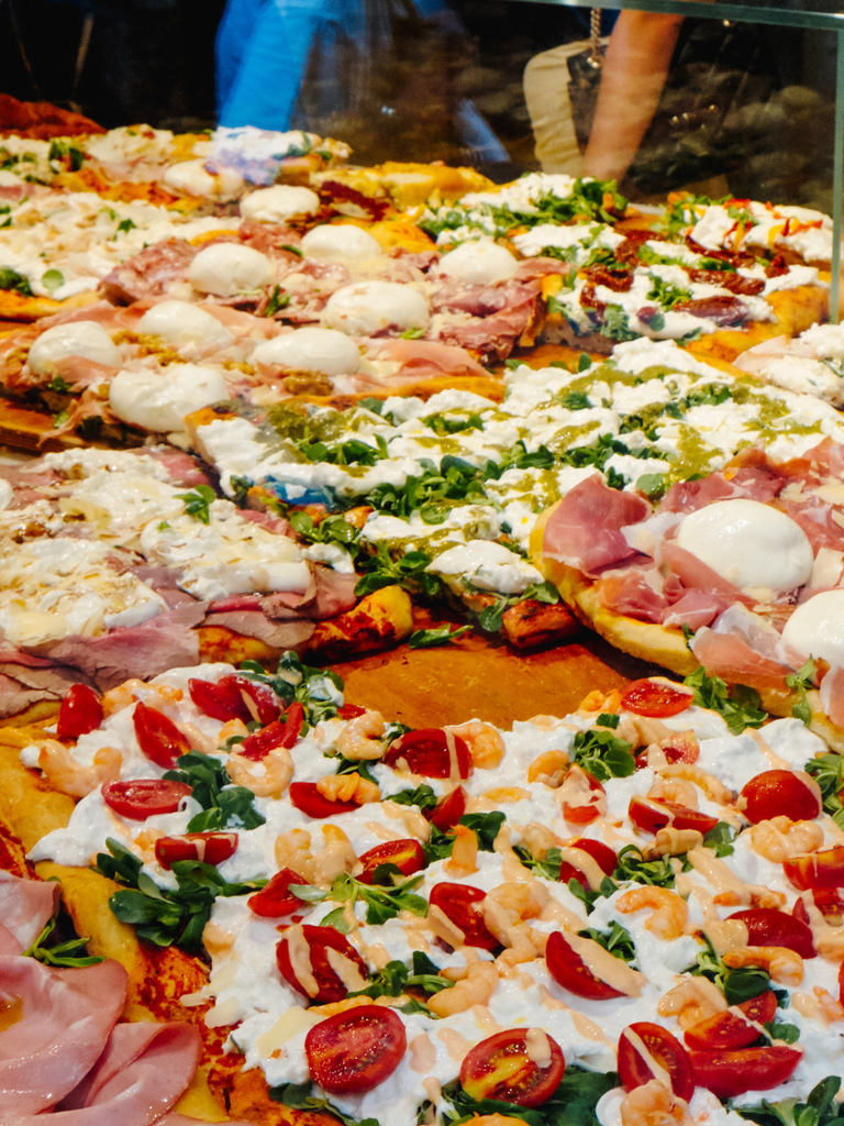 Rectangular slices of Roman pizza al taglio on a tray