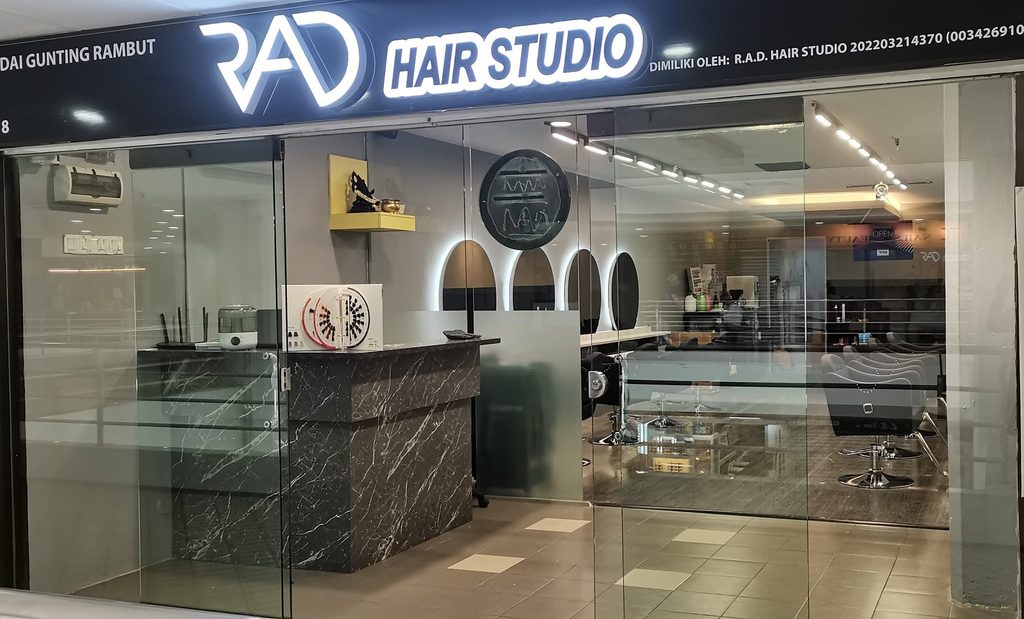 R.A.D. Hair Studio's glass-fronted shop with backlit signage in Holiday Plaza