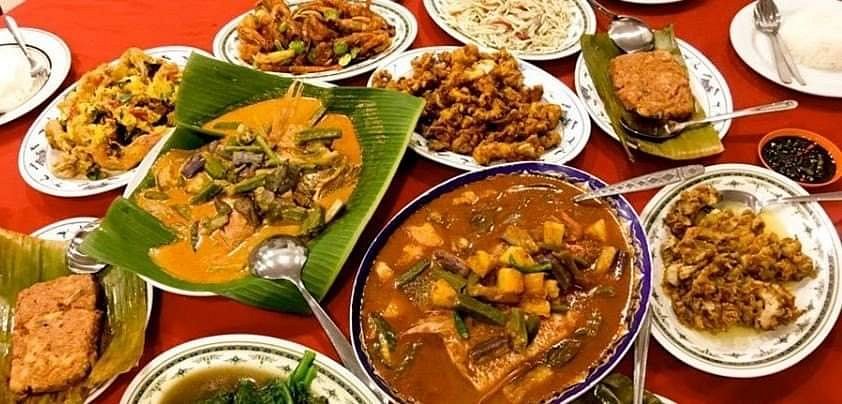 Curry fish head in tamarind gravy served on a banana leaf with a zi char spread at Restoran Sulam