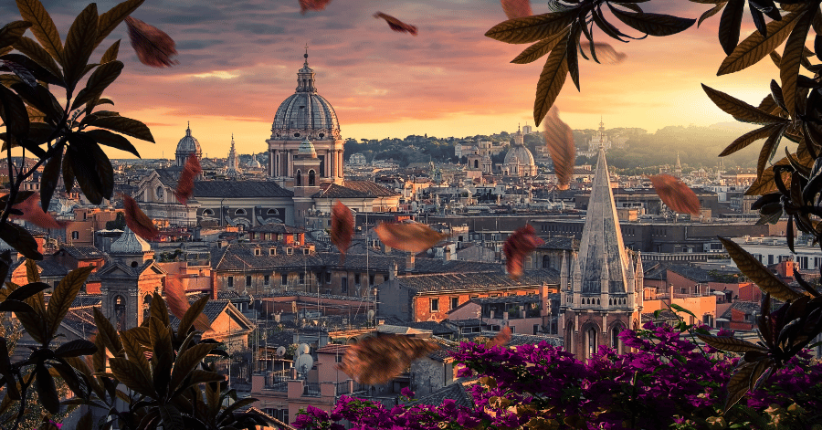 Rome's skyline at sunset, domes and rooftops framed by leaves and bougainvillea