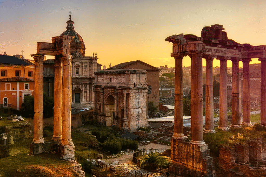 Roman Forum ruins and ancient temple columns silhouetted at sunset