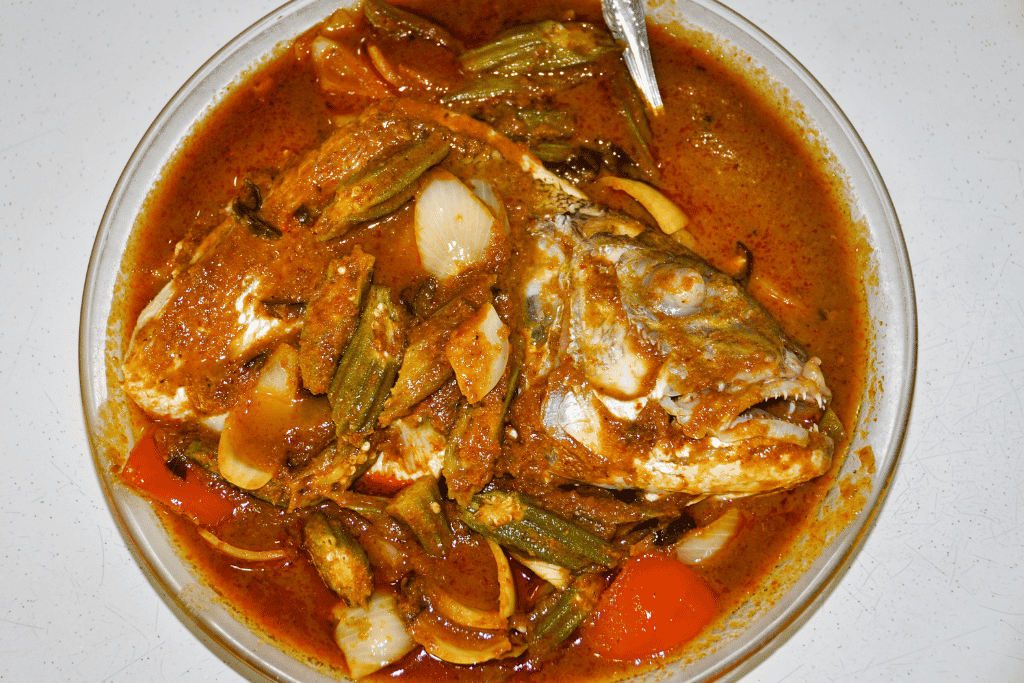 A whole fish head in spicy tamarind curry gravy with okra and tomato