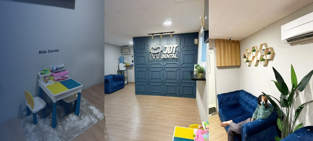 JDT Dental clinic with a blue panelled reception wall, blue sofas and a children's play table in the kids corner