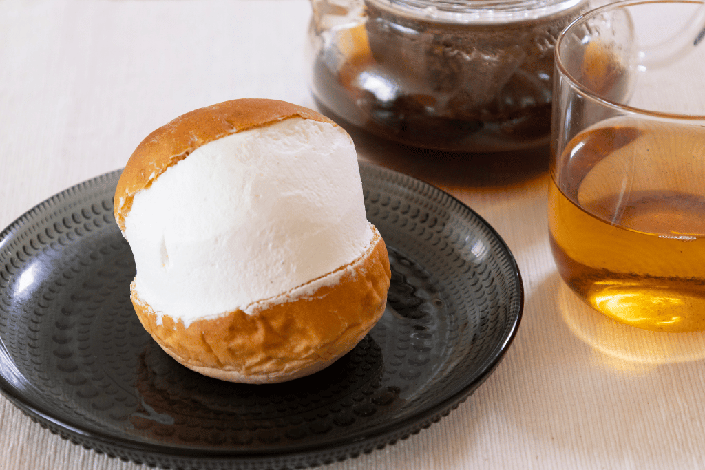 A maritozzo cream bun split open on a plate