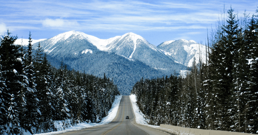 A snow-lined road leading toward the Canadian Rockies
