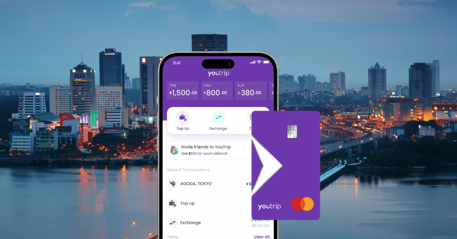 YouTrip app showing currency balances beside a purple YouTrip card, set against a city skyline at dusk